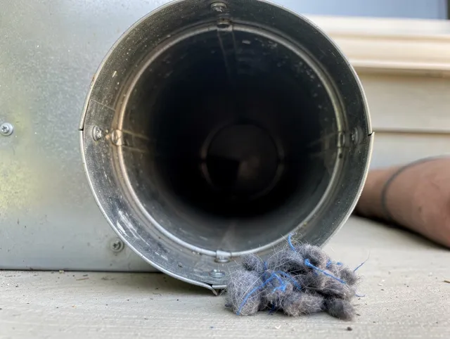 Uxbridge Dryer Vent Cleaning technician using specialized equipment to clear severe dryer vent blockage in Uxbridge